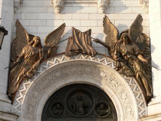 Горельефы Храма Христа Спасителя. Левая арка малых врат. Два Ангела с наклоненными знаменами, на которых изображен крест