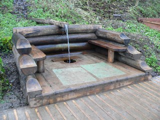 Водопад Гремячий ключ. Источник. Вода стекает по деревянному желобу